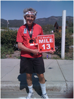 Don Keele holding the Mile Marker 13 sign while running the marathon "Run the Bear" in Big Bear California -- www.dbkeele.com